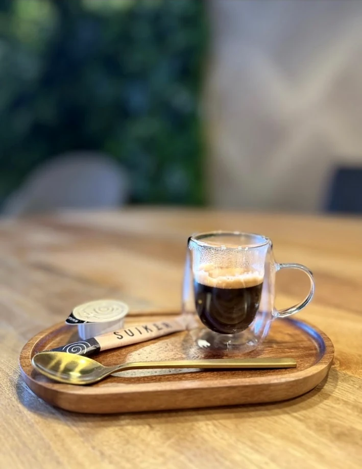 Espresso geserveerd op een houten dienblad bij Kuzina
